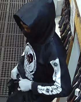 A person in a black and white hoodie at the scene of the crime.