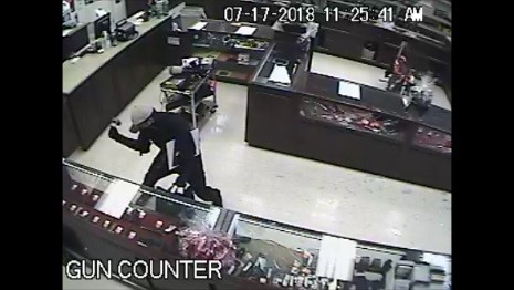 Robbery suspect smashing display cases.