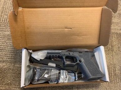 Close-up of handgun and magazine in a box