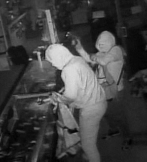 Two suspects grabbing items from display