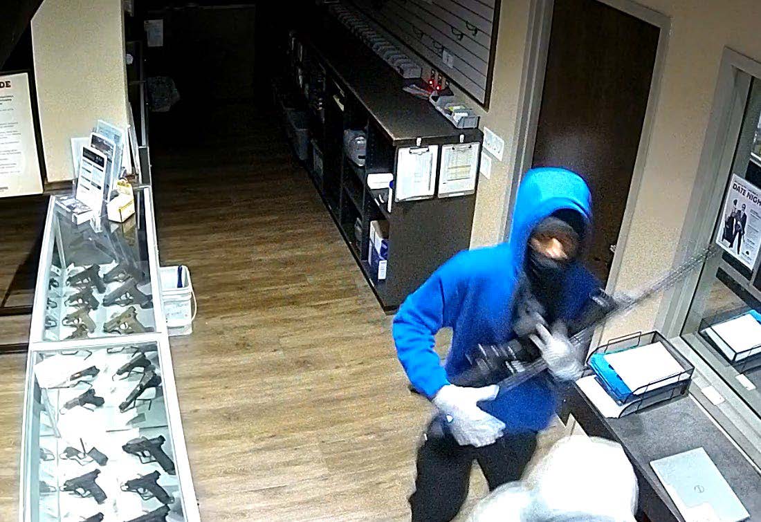Suspect in blue hoodie holding firearms