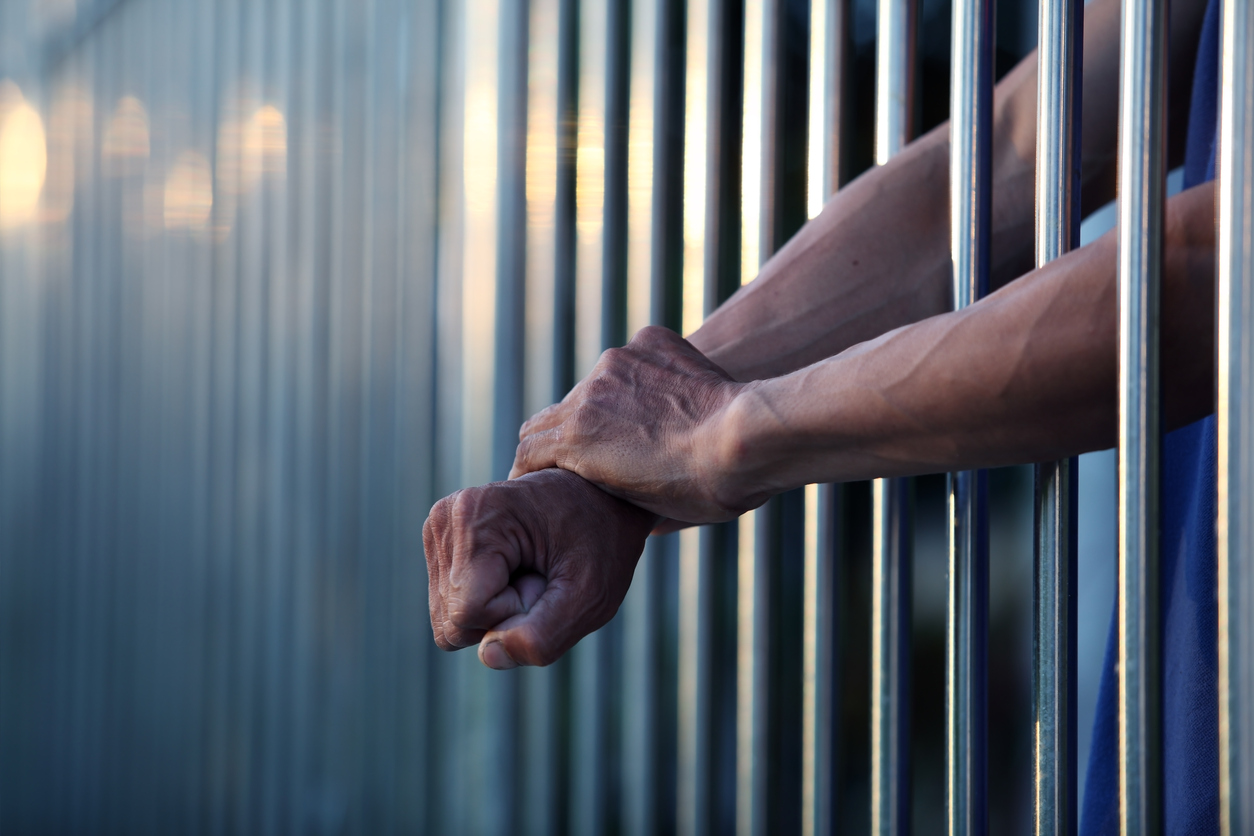 Image of the hands of a person in jail