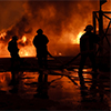 Burning building with firemen responding