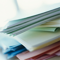 Image of a stack of forms and publications on a table.