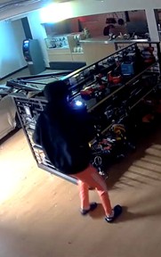 Still-frame photo from surveillance video footage showing an individual in the shop during the burglary.