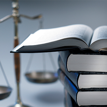 A stack of books next to metal balance scales