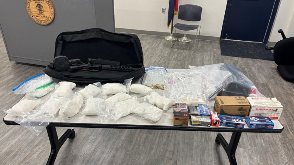 Illegal guns, ammunition, and narcotics seized as a result of Operation Show Me Justice Seized firearms, ammunition, and narcotics on a table.