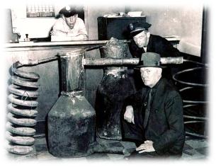 Image of an agent and police officers next to a siezed still.