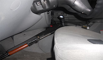 Image of same automobile interior front seat containing a how powered rifle