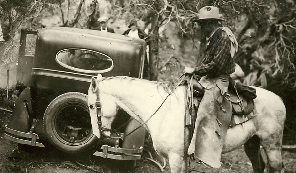 Image of a search volunteer on horseback examining Ray Sutton's abondened car and crime scene.