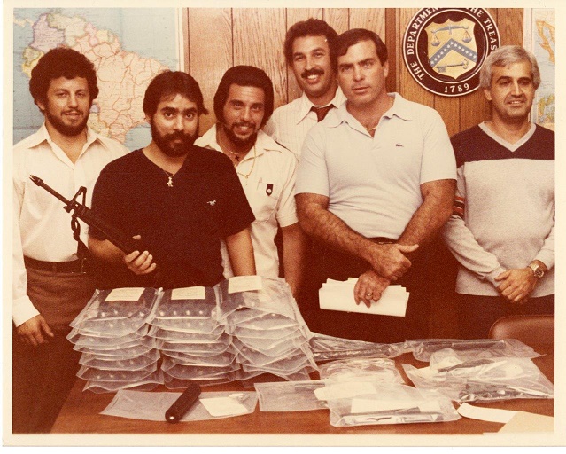 Image of Special Agent Ariel Rios and other special agents posing next to seized evidence.