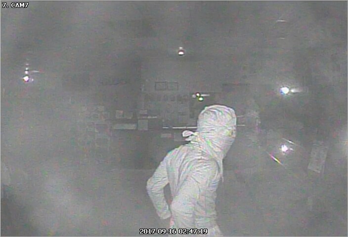 Second person of interest seen wearing all white clothing in the midst of the robbery. 