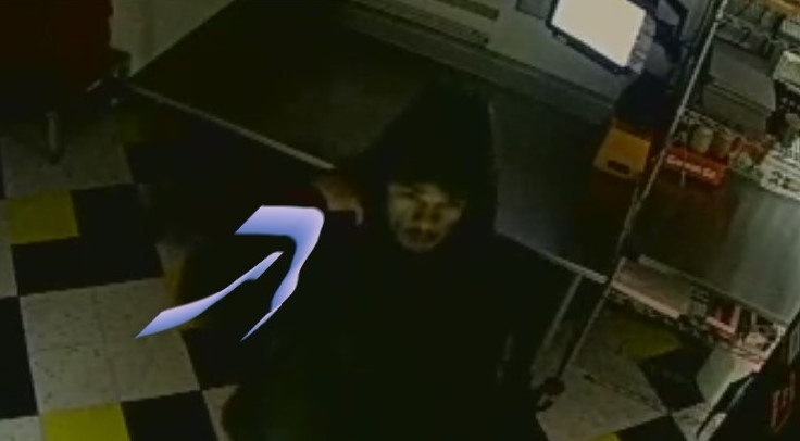 Unidentified male suspect in dark clothing with a hood over his head walking into Dublin Pawn Shop