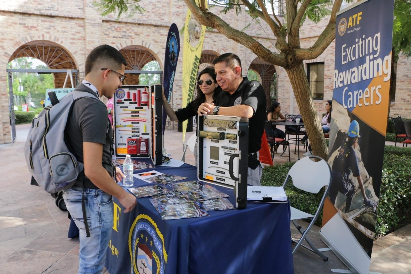 Industry Operations Investigator Edward working a recruiting booth at a local community college.