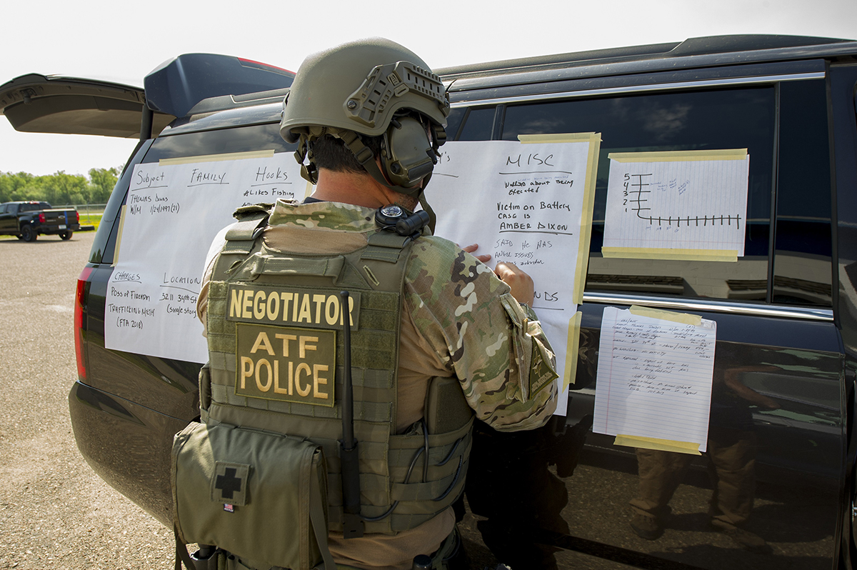 An ATF crisis negotiator drafts up a situation board to manage a crisis
