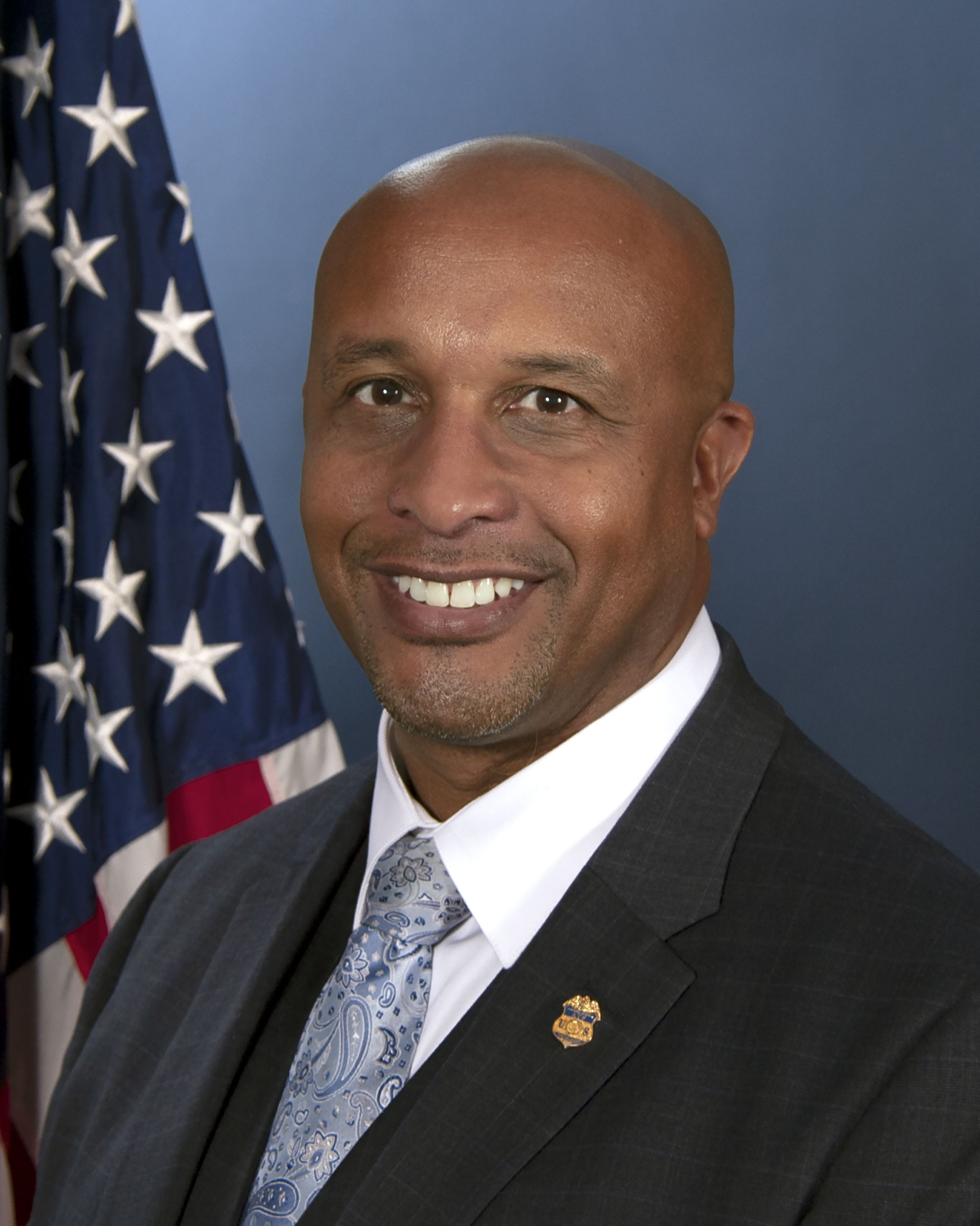 retrato oficial de un hombre frente a la bandera