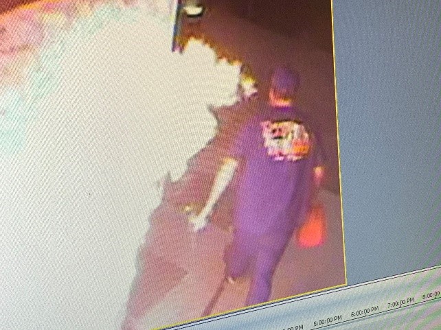 Security footage of arson suspect walking away from a fire with a gas can.