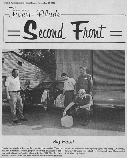 Swainsboro Forest-Blade page with image of Alcohol, Tobacco Tax and Firearms Division special investigators looking at a jug of confiscated non-tax whiskey.