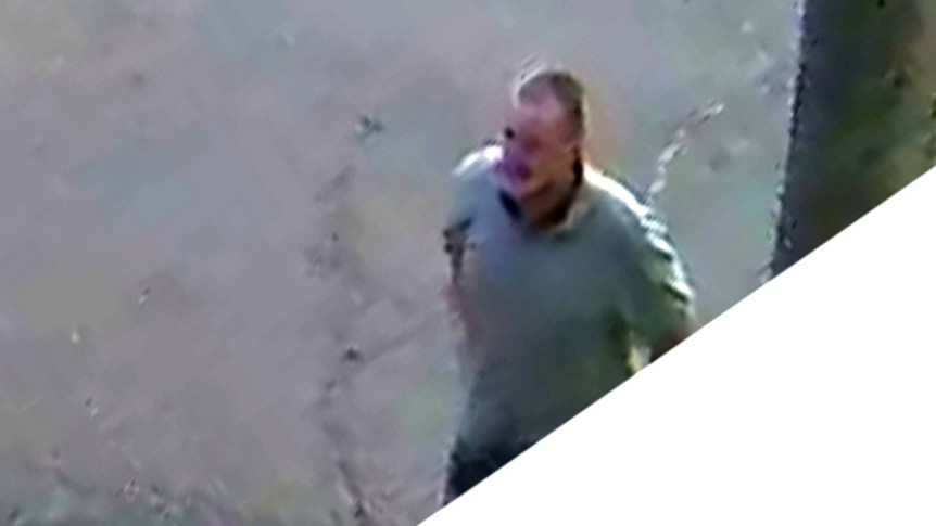 Front view of male suspect in gray polo shirt