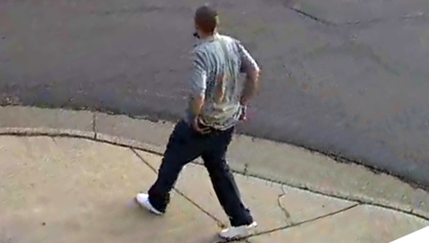 Side view of male suspect in gray polo shirt, dark pants and white shoes