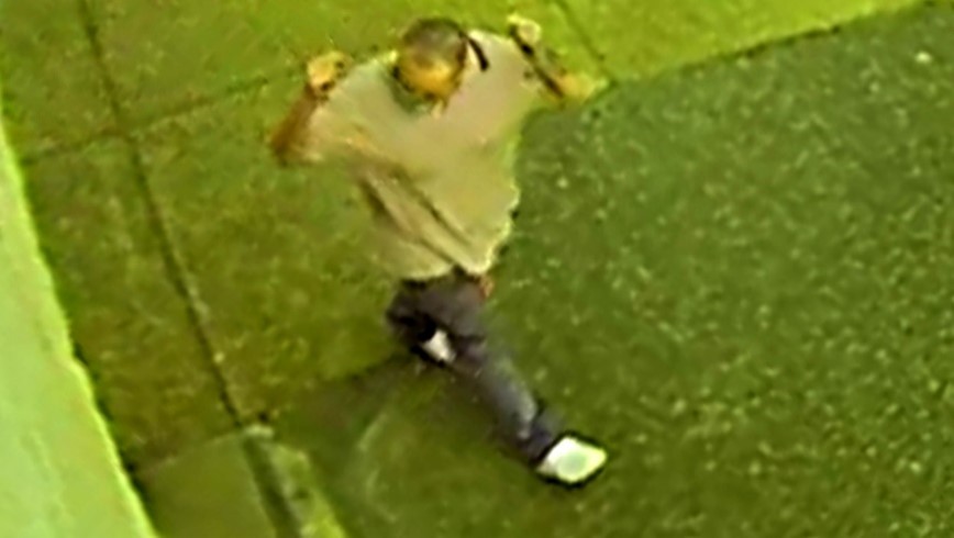 Top view of male suspect in gray polo shirt, dark pants and white shoes