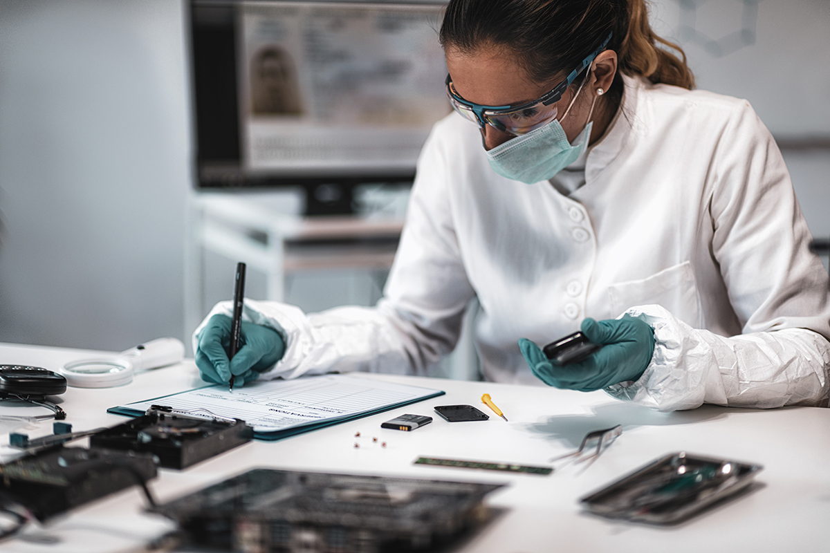 A forensics specialist examines a confiscated mobile phone