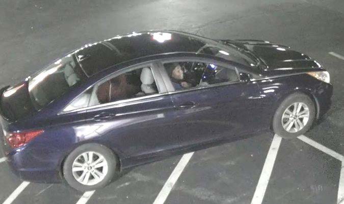 Suspects sitting in a blue car.