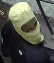 A person with a light-colored face covering at the scene of the crime.