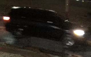 A dark-colored car at the scene of the crime.