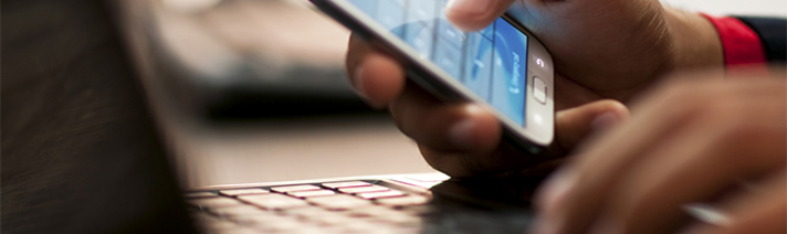 Person using a smartphone and a laptop