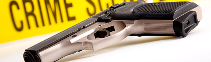 Gun with crime scene tape in background