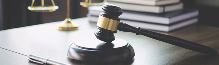 A gavel, pen, and justice scales