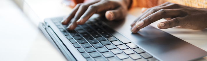 Person typing on a laptop keyboard