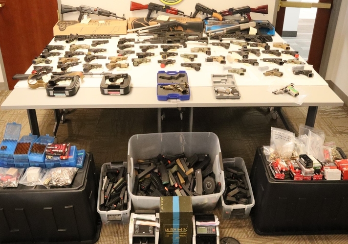 Different types of firearms on the table and floor