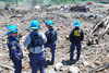 Agents standing in debris having a discussion