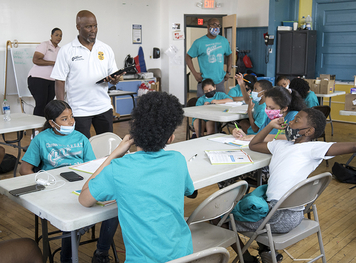 G.R.E.A.T instructor talking to group of kids sitting at a table