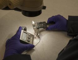 An examiner analyzes a piece of possible evidence in the laboratory.