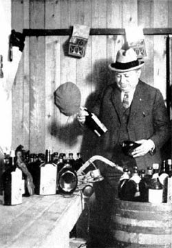 Prohibition Agent Izzy Einstein examines whiskey bottle labels in South Brooklyn