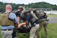 Image of law enforcement carrying team members during training.