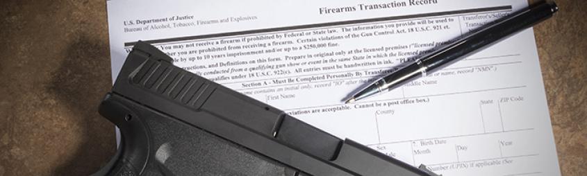 Firearm and pen on top of an ATF Form