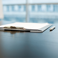 Image of a pen and clipboard.