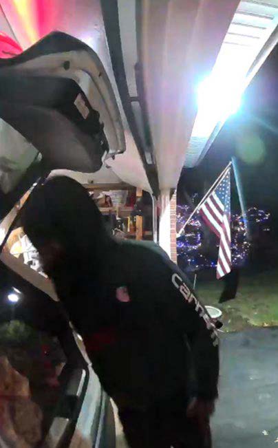 Blue Ash carjacking suspect looking in the open trunk of the carjacked vehicle.