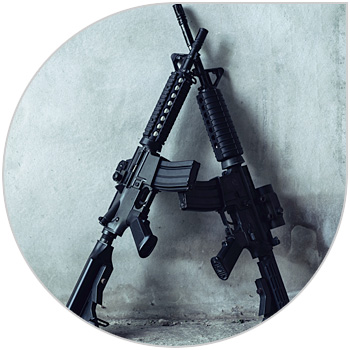 Two firearms resting against a wall