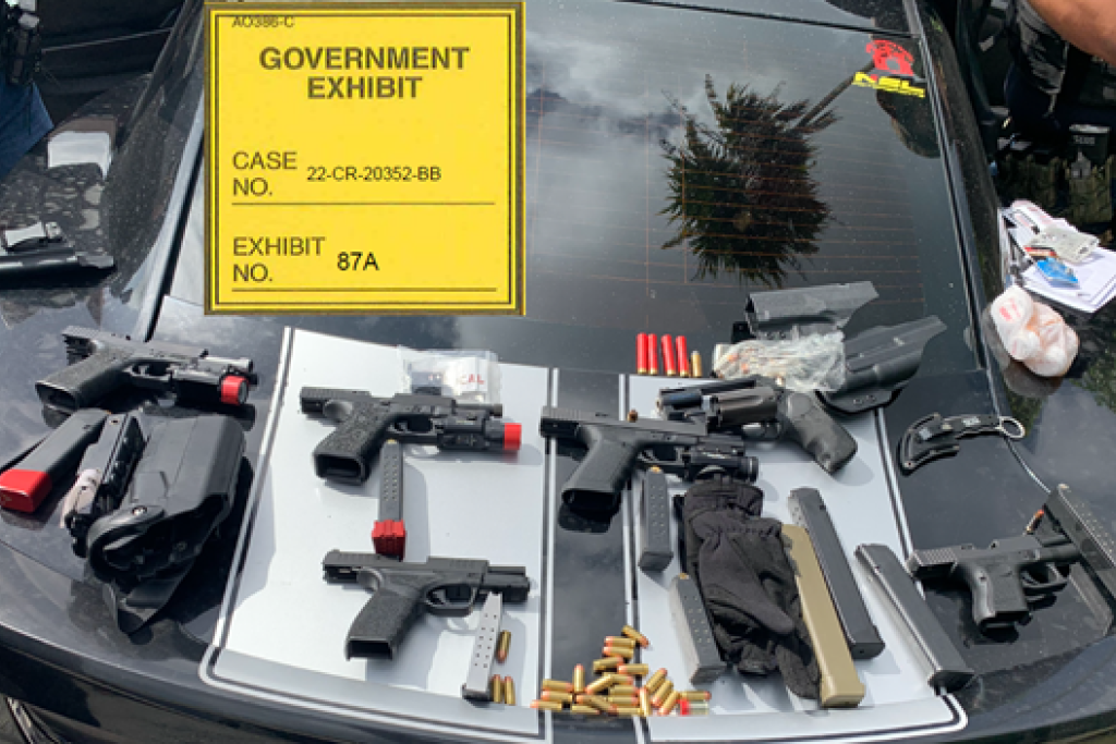 Additional guns and ammunition arranged on the trunk of a car, collected as evidence by law enforcement agents.