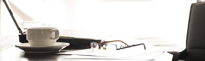 Image of laptop and glasses and newspaper