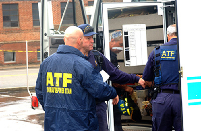 Special Response Team agents grabbing items out of the ATF truck during an investigation.