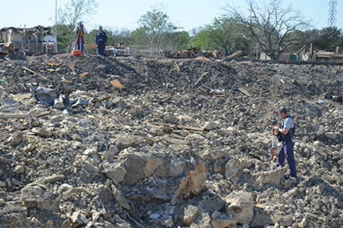Agent standing in debris will a shovel in their hand