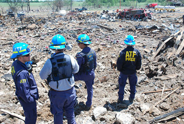 Agents standing in debris having a discussion