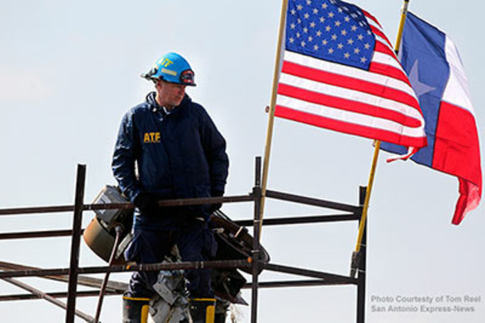 Agent standing next to an American flag