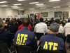 Group of agents sitting in a classroom listening to a briefing